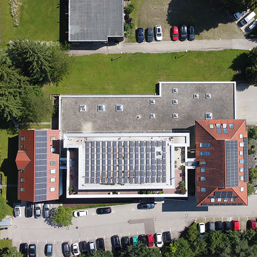 Luftbild des Hauptsitz von Kling Consult mit Ziegeldächern,einem Parkplatz und umgebenden Grünflächen