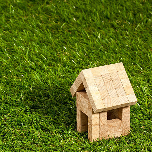 Kleines Modell-Holzhaus im Gras